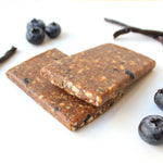 Energy bars with blueberries and vanilla pods on a white background